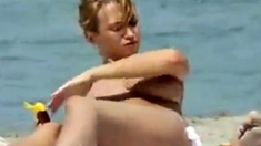 Oiling boobs on topless beach