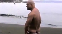 Asian bodybuilder barely covered at the beach